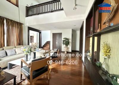 spacious living room with modern furniture and staircase
