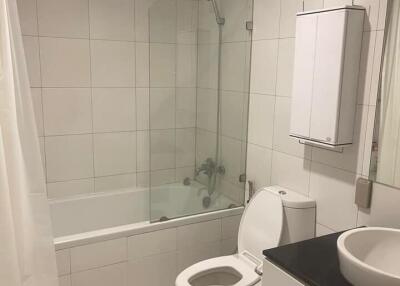 Modern white tiled bathroom with bathtub, shower, and sink