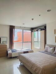 Spacious bedroom with a double bed, single bed, wardrobe, and a window with city view