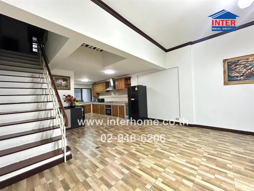 Modern kitchen with wooden cabinets and staircase