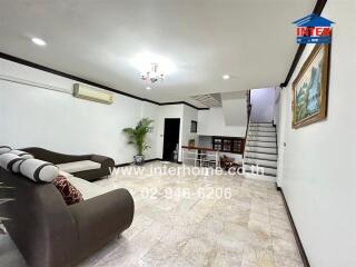 Spacious living room with modern furniture and a view of the staircase