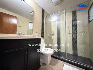 Modern bathroom with glass shower and dark wood vanity