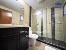 Modern bathroom with glass shower and dark wood vanity