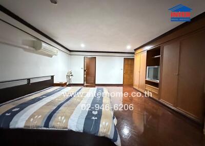 Spacious bedroom with wooden flooring and built-in wardrobe