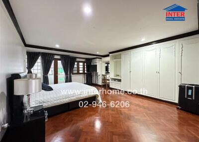 Spacious bedroom with wooden flooring and ample storage