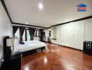 Spacious bedroom with wooden flooring and ample storage