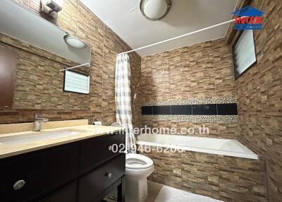 Modern bathroom with tile walls, a bathtub, and a vanity