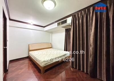 Bedroom with a bed, wooden floor and closed curtains