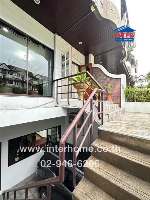 Exterior view of a building with a staircase and a potted plant