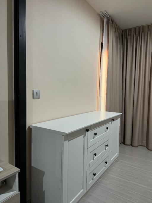 Bedroom with white dresser and closed curtains