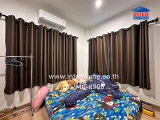 Bedroom with curtains, bed, and air conditioner