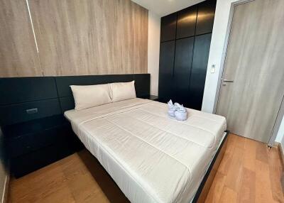 Modern bedroom with minimalist design featuring a bed with a wood panel backdrop