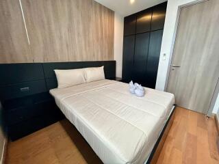 Modern bedroom with minimalist design featuring a bed with a wood panel backdrop