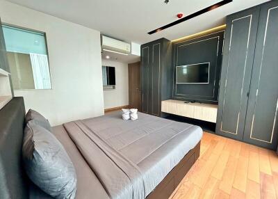Modern bedroom with built-in wardrobe and mounted TV