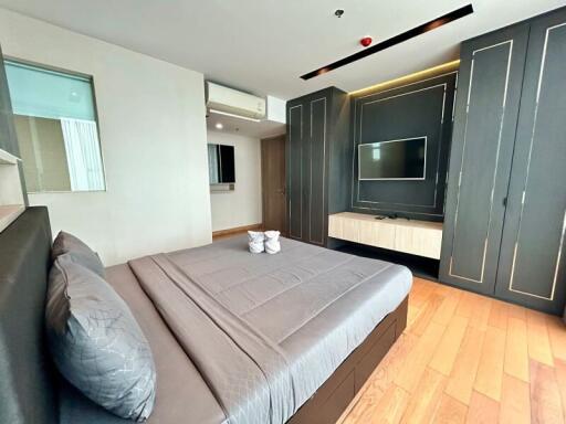 Modern bedroom with built-in wardrobe and mounted TV