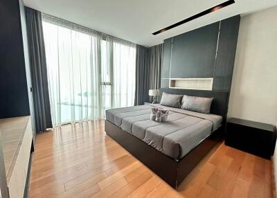 Modern bedroom with large windows and wooden flooring