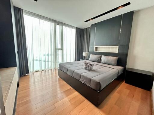 Modern bedroom with large windows and wooden flooring