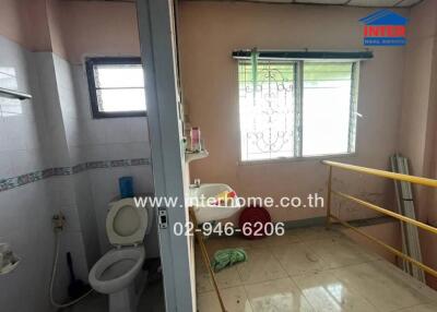 Bathroom with adjacent room featuring a window and washing machine