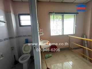 Bathroom with adjacent room featuring a window and washing machine