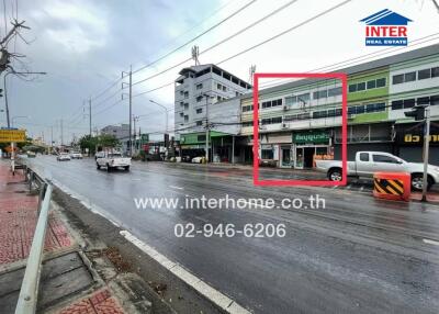 Street view of commercial buildings with contact information