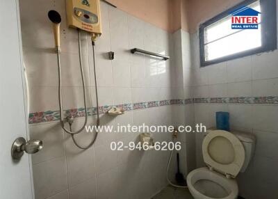 Bathroom with shower, water heater, and toilet