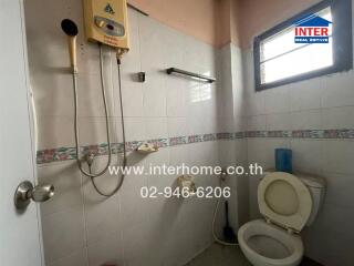 Bathroom with shower, water heater, and toilet