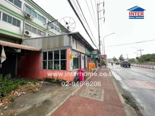 Street view of a commercial building with signage and contact information