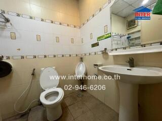 Bathroom with toilet, urinal, sink, and wall tiles