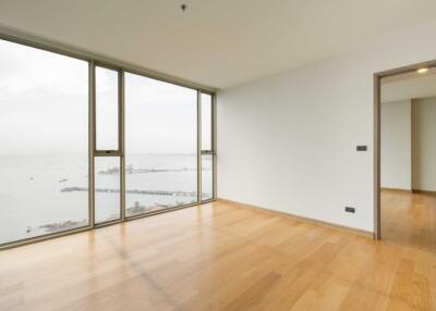Spacious bright living room with wooden flooring and large windows with sea view