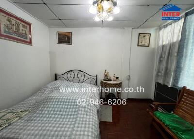 Small bedroom with bed, chandelier, and furniture