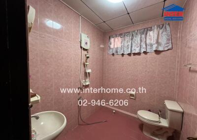 Bathroom with pink tiles and basic fixtures