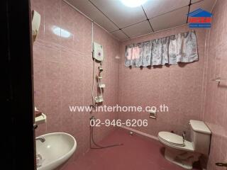 Bathroom with pink tiles and basic fixtures