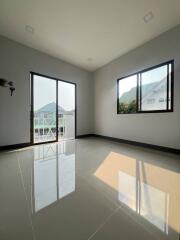 Empty bedroom with large windows and tiled floor