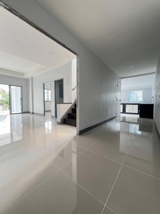 Open space with tiled floor, stairway, and hallway