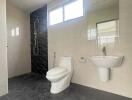 Modern bathroom with shower, toilet, sink, and large mirror