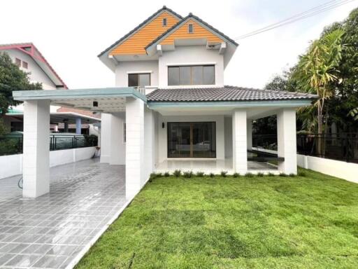 Exterior view of a two-story house with a tiled roof and a front lawn