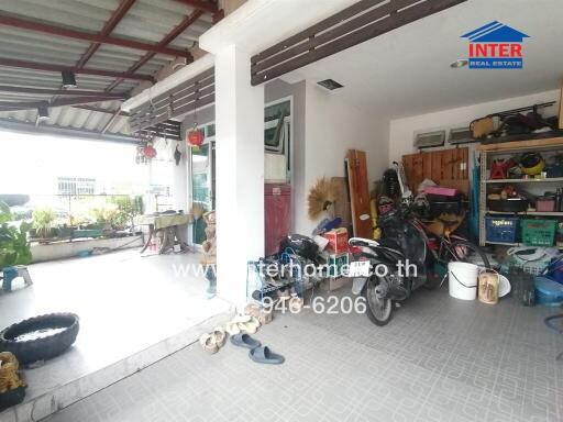 An outdoor space with a partially covered patio and various items stored.