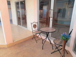 A patio area with a small round table, two chairs, and a potted plant