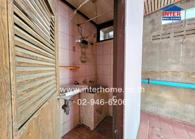 Small bathroom with wooden door and wall tiles