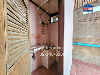 Small bathroom with wooden door and wall tiles