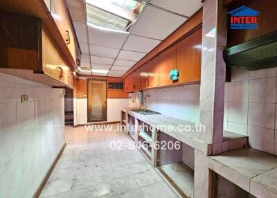 Spacious kitchen with wooden cabinets and tiled floor