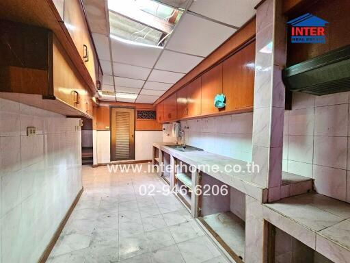 Spacious kitchen with wooden cabinets and tiled floor