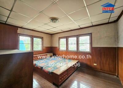 Spacious bedroom with large windows and wood paneling