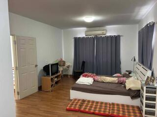 Bedroom with a bed, desk, curtains, and miscellaneous items