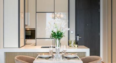 Modern dining area with elegant table setting and kitchen in background