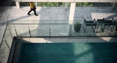 View of a pool area with glass railing and seating