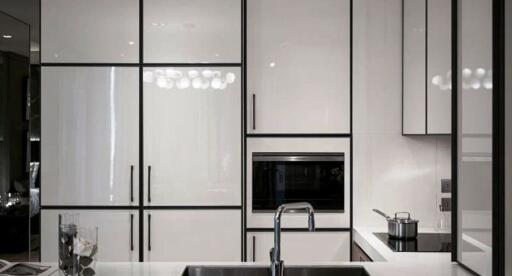 Modern kitchen with white cabinetry, built-in appliances, and a sink