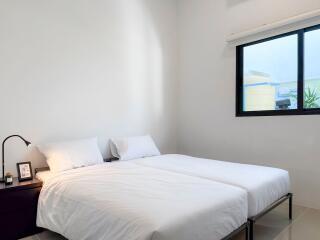 Modern bedroom with twin beds and a large window