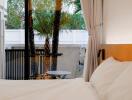 Cozy bedroom with a view of an outdoor patio and palm trees.