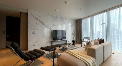 Modern living room with marble wall, large windows, and contemporary furniture